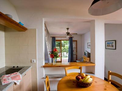 Heller Wohn-Essbereich mit Holzmöbeln, Pflanzen und offener Terrassentür mit Blick ins Freie.