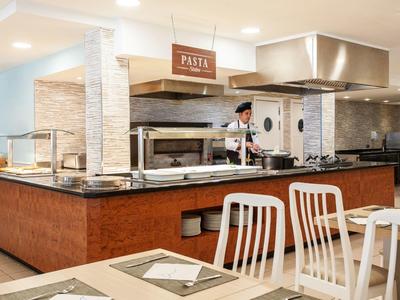 Nowoczesna kuchnia samoobsługowa ze stacją makaronu w jasnej restauracji.