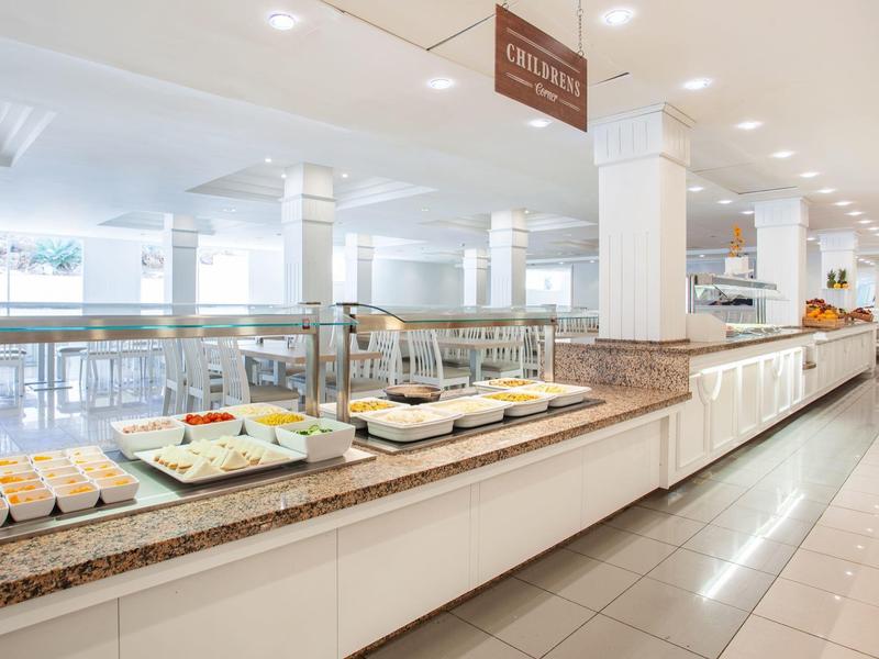 Strefa bufetu w jasnej, nowoczesnej restauracji hotelowej z różnorodnymi potrawami.