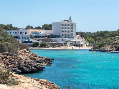 Budynek hotelu przy wybrzeżu z czystą turkusową wodą i skalistym brzegiem