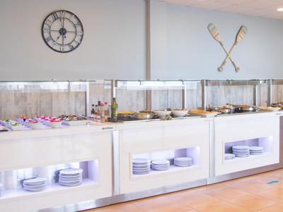 Buffet in una stanza luminosa con piatti ed elementi decorativi sulla parete.