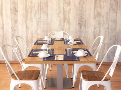 Tavolo da pranzo moderno con sedie in metallo bianco e tazze da caffè in una stanza luminosa