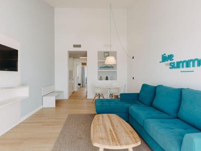 Modern living room with blue sofa, wooden coffee table, and wall decoration 'love summer'