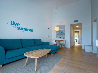 Modern living room with blue sofa and wooden table in a holiday apartment