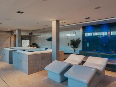 Área de bienestar moderna con jacuzzis y tumbonas cómodas en un hotel.
