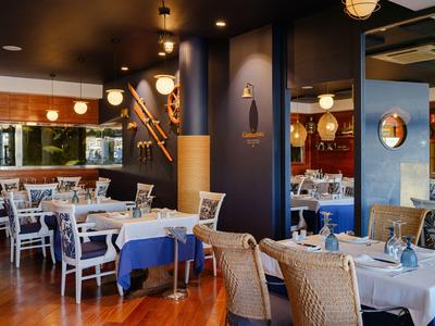 Restaurante moderno de hotel con mesas elegantemente preparadas y ambiente acogedor.