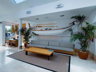Modern lounge area with hammock, sofa, table, and plants.