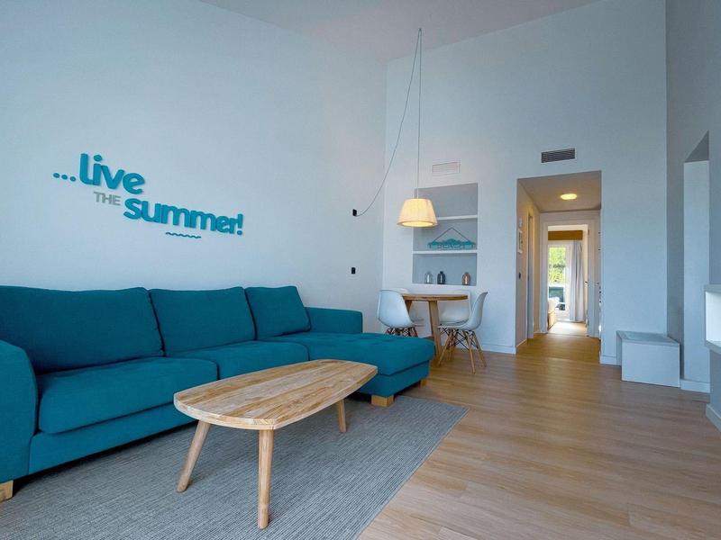 Modern living room with blue sofa and wooden table in a holiday apartment