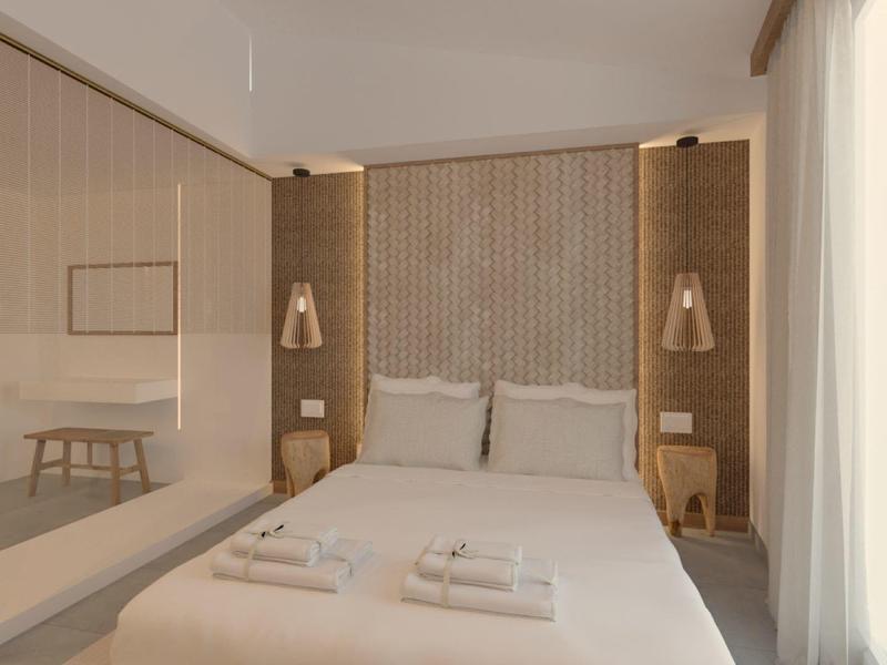 Camera d'albergo moderna con letto matrimoniale, comodini e grandi finestre con tende.