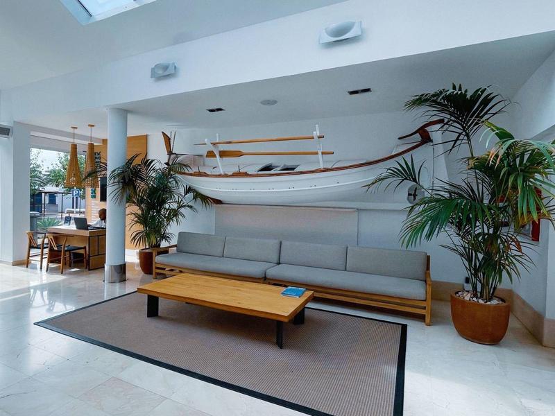 Modern lounge area with hammock, sofa, table, and plants.