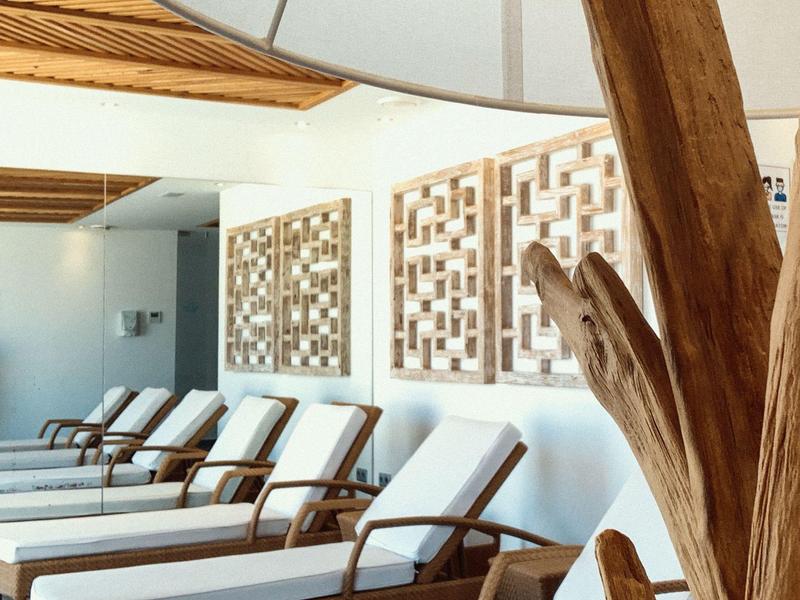 Modern spa area with white loungers and decorative wooden wall panels.