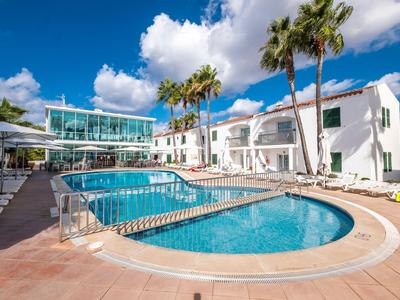Nowoczesny basen hotelowy z leżakami i palmami pod błękitnym niebem