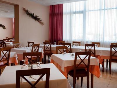Bright dining room with set tables and wooden chairs.