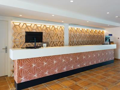 Moderne hotelreceptie met artistieke houten bekleding en betegelde vloer.