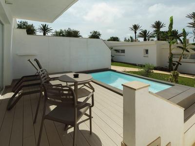 Moderne buitenruimte met zwembad en zitgelegenheid in een hotelomgeving.