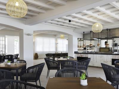 Moderne binnen eetruimte met zwarte stoelen en tafels in een lichte omgeving.