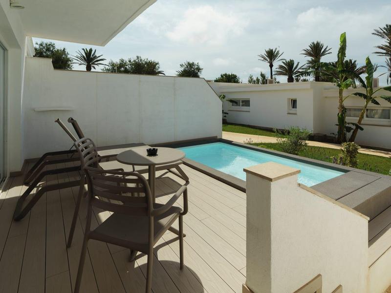 Moderne buitenruimte met zwembad en zitgelegenheid in een hotelomgeving.