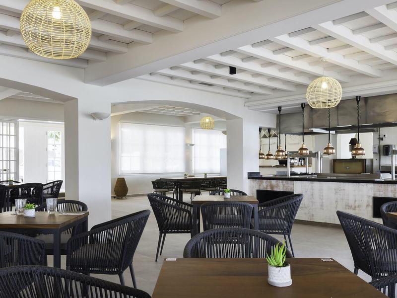 Moderne binnen eetruimte met zwarte stoelen en tafels in een lichte omgeving.