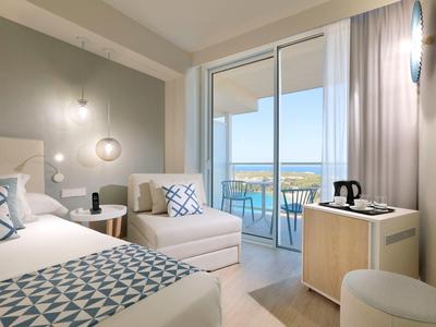 Stylowy pokój hotelowy z balkonem i widokiem na morze.