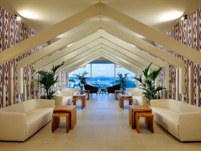 Jasny i nowoczesny salon z sofami i widokiem na morze przez duże okna.