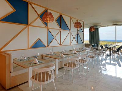 Nowoczesna jadalnia z dużymi oknami z widokiem na morze.