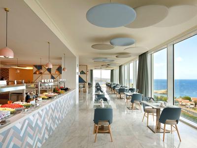 Nowoczesna sala restauracyjna z dużymi oknami z widokiem na morze.