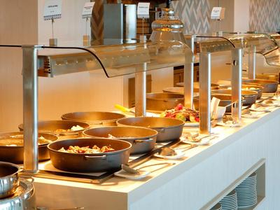 Bufet z wieloma gorącymi potrawami w dobrze oświetlonym pomieszczeniu.