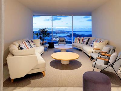 Nowoczesny salon z białymi sofami i panoramicznym widokiem na morze.