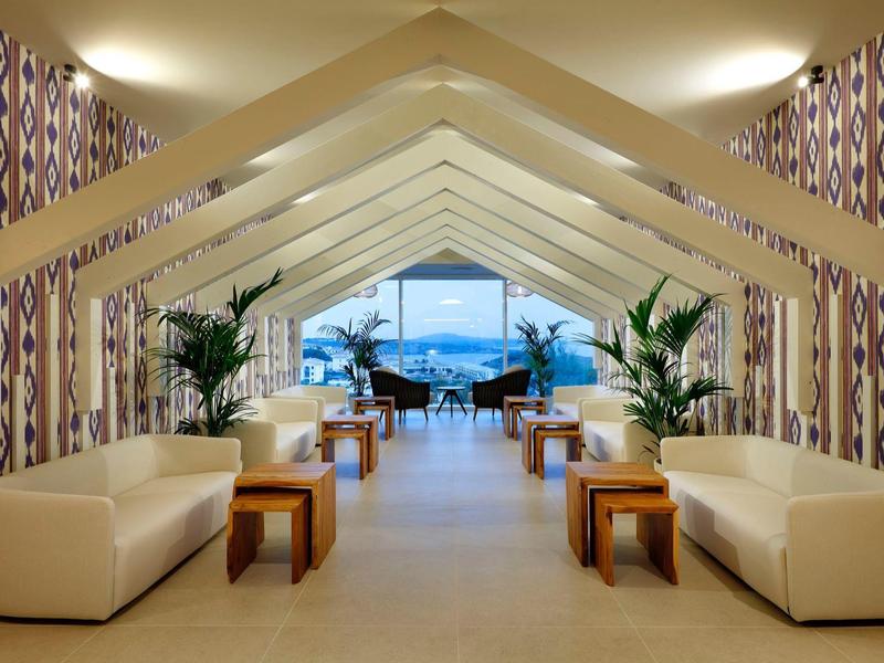 Jasny i nowoczesny salon z sofami i widokiem na morze przez duże okna.