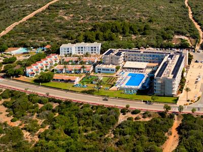 Vista aerea di un complesso alberghiero con piscina in un ambiente rurale verde.