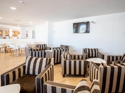 Lounge moderna con poltrone a righe e atmosfera accogliente in uno spazio luminoso.