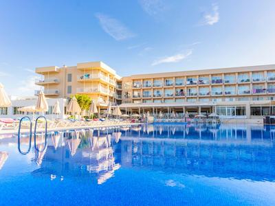 Hotel moderno con grande piscina esterna blu sotto un cielo limpido