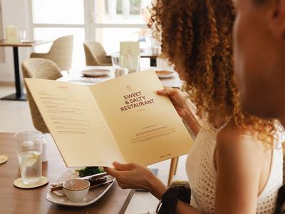 Couple assis dans un restaurant lisant le menu à la lumière du jour.