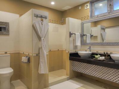 Moderne Badezimmer mit Duschkabine, zwei Waschbecken, WC und großen Spiegeln, beige Wandfliesen.