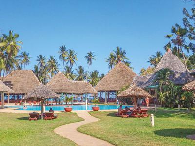 Resort mit Palmen, Strohdach-Pavillons und Swimmingpool unter klarem blauem Himmel.