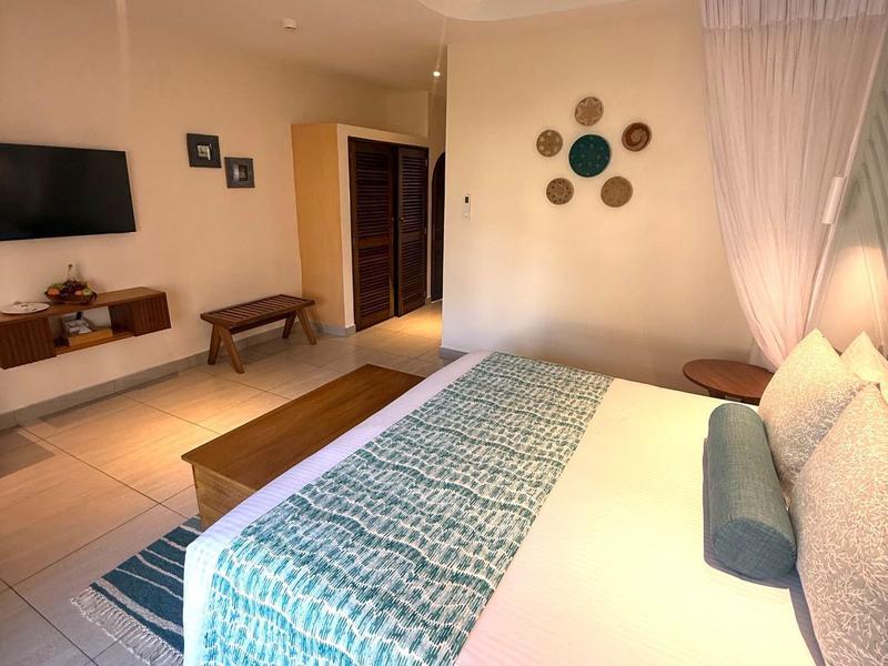 Camera d'hotel moderna con letto grande, TV, tende e decorazioni murali eleganti.