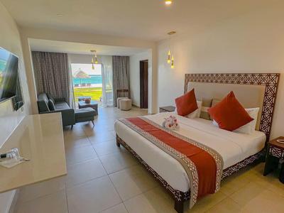 Moderní hotelový pokoj s velkou postelí, televizí s plochou obrazovkou a posezením s výhledem ven.