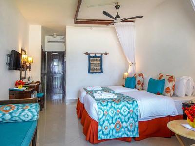 Gemütliches Schlafzimmer mit Doppelbett, türkisfarbenen Akzenten und warmem Licht.