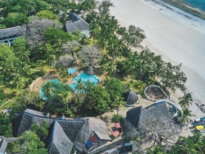 Überblick über ein Resort mit Pools und direktem Zugang zu einem weißen Sandstrand.