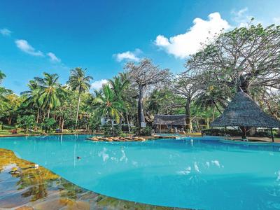 Großer Pool mit Palmen und Sonnendach bei klarem Himmel im tropischen Resort