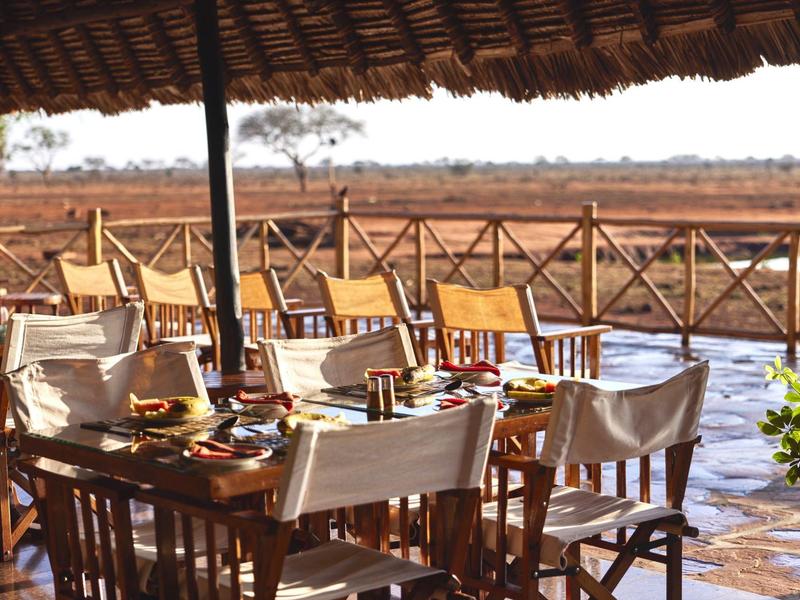 Terrasse mit gedecktem Tisch und Blick auf ein weites, trockenes Grasland