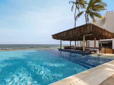 Infinity-Pool mit Swim-up-Bar und Meerblick unter blauem Himmel