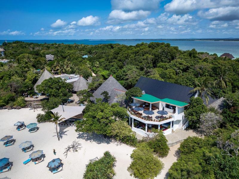Complexe balnéaire avec bungalows, espaces lounge et végétation luxuriante au bord de la côte.
