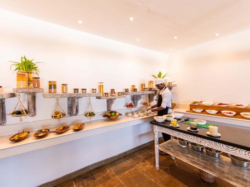 Buffet avec différentes options de petit-déjeuner dans un restaurant d'hôtel à l'ambiance lumineuse.