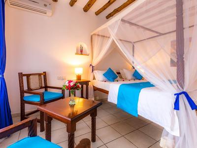 Camera d'hotel luminosa con letto a baldacchino, mobili in legno e accenti blu.