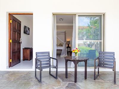 Patio con due sedie e un tavolo di fronte a porta e finestra della stanza aperte