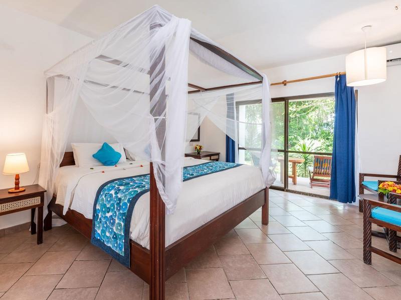 Accogliente patio con tavolo in legno e due sedie con vista su un giardino verde.