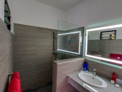 Moderne badkamer met verlichte spiegel, wastafel en douchecabine.