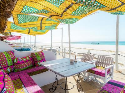 Cozy beach terrace with colorful cushions and sea view.