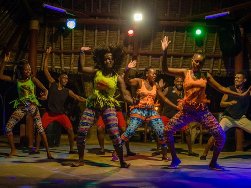 Grand miroir de salle de bain avec lavabo, savon, lotion et lampe murale.